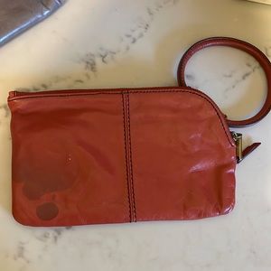 Rust colored HOBO wristlet. Small stain